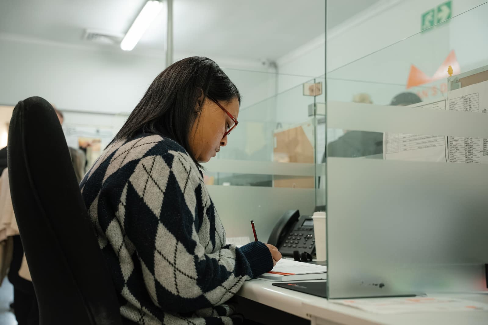 A Malan's Dairy staff member writing up an order at the reception desk